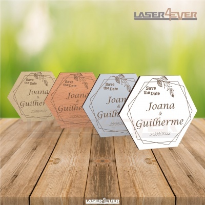 Cartões hexagonais de madeira com texto 'Save the Date Joana & Guilherme 25/09/2022' sobre mesa de madeira