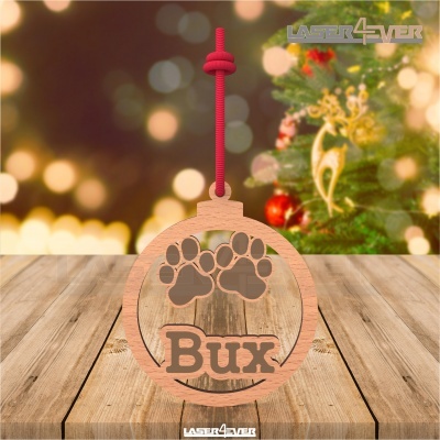 Ornamento de madeira redondo com palavra Bux e pegadas, com cordão vermelho em fundo natalício