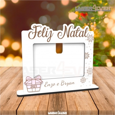 Moldura fotografica branca com texto Feliz Natal e nomes Enzo e Bryan sobre mesa de madeira