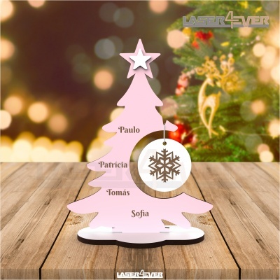 Árvore de Natal cor-de-rosa com nomes gravados e floco de neve pendurado sobre mesa de madeira