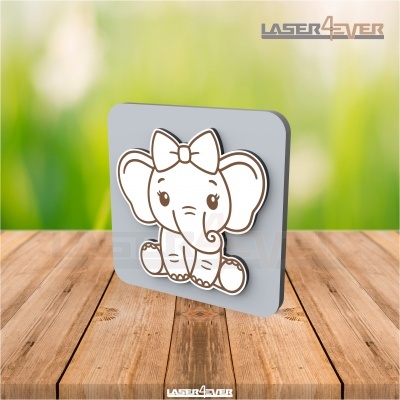 Objeto decorativo cinzento com elefante branco com laço sentado numa mesa de madeira.