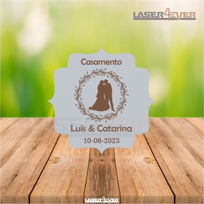 Placa decorativa cinza para casamento com nomes e data, sobre superfície de madeira