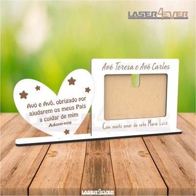 Porta-fotos em madeira branca com formas de coração e retângulo, texto em castanho, sobre superfície de madeira