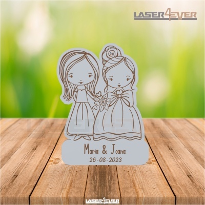 Figura decorativa em acrílico com desenho a laser de duas figuras femininas estilizadas e texto gravado