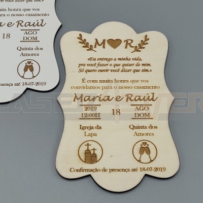 Convite de casamento em madeira com texto gravado e símbolos de igreja e casal