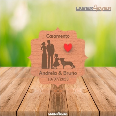 Placa decorativa de madeira com silhuetas de casal, criança e cão, coração vermelho e texto de casamento.