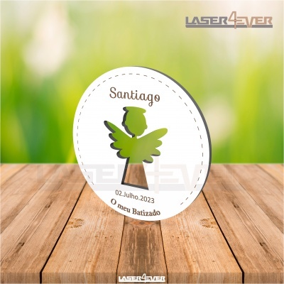Etiqueta oval branca com anjo verde e texto para batizado sobre madeira