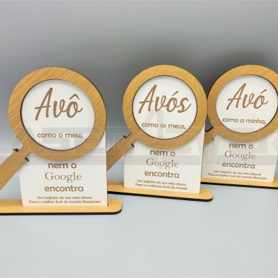 Placas decorativas de madeira e acrílico em forma de lupa com texto em português sobre avós