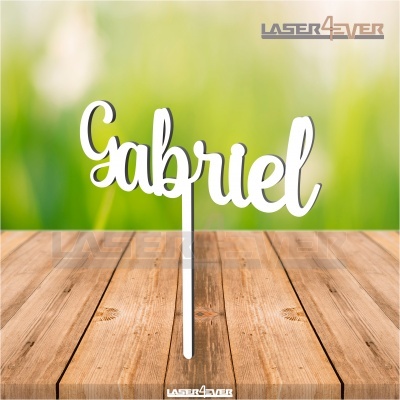 Nome Gabriel em letra cursiva branca sobre base em mesa de madeira