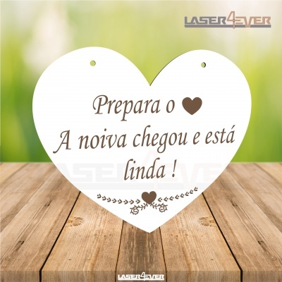 Placa branca em forma de coração com texto em português sobre madeira clara