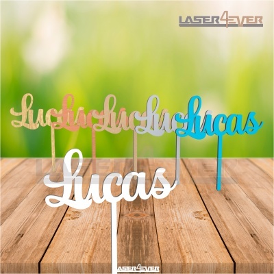 Cake toppers em madeira com o nome Lucas em várias cores sobre madeira