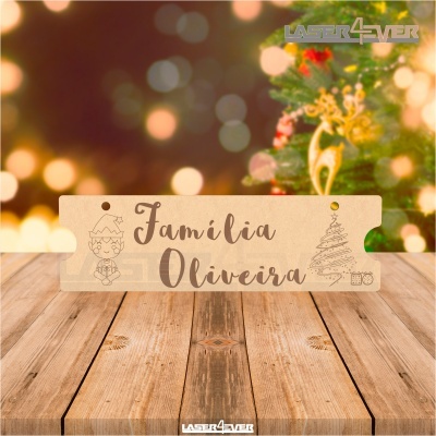 Placa decorativa de madeira com texto 'Família Oliveira' e desenhos natalícios