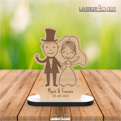 Escultura de casal de noivos em madeira com base branca e preta e texto gravado