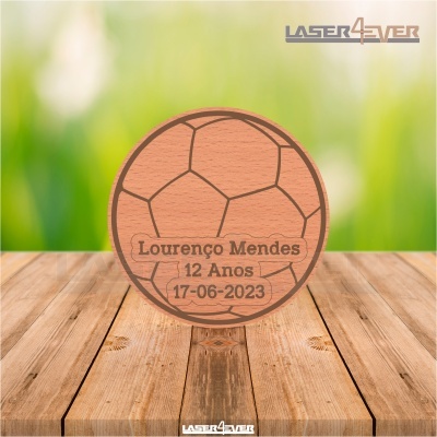 Produto de madeira em forma de bola de futebol com texto gravado 'Lourenço Mendes 12 Anos 17-06-2023'
