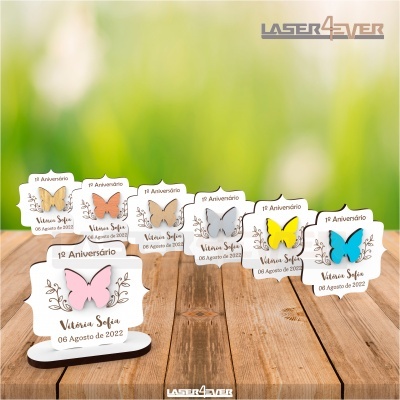 Cartões decorativos de aniversário com borboletas coloridas em madeira em fundo de mesa de madeira.