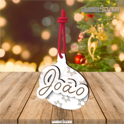 Ornamento de Natal branco com nome João e cordão vermelho sobre madeira