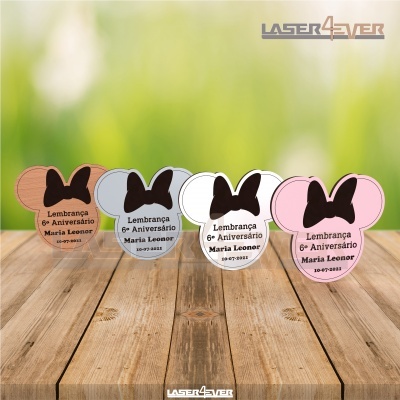 Lembranças em forma da cabeça da Minnie Mouse em várias cores sobre superfície de madeira