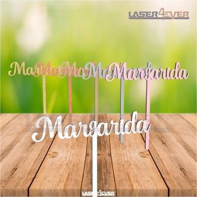 Topo de bolo com o nome 'Margarida' em várias cores sobre superfície de madeira