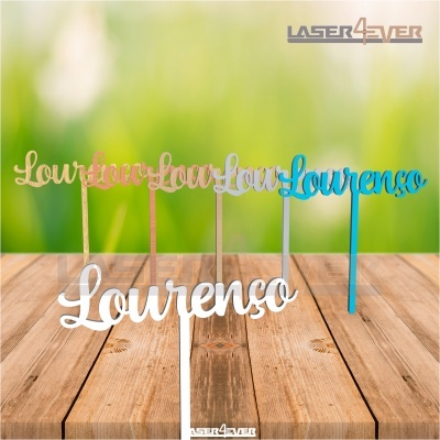 Cinco toppers de bolo com o nome Lourenço em várias cores sobre mesa de madeira