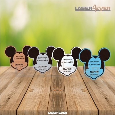 Lembranças de aniversário em forma de cabeça de rato em várias cores sobre madeira