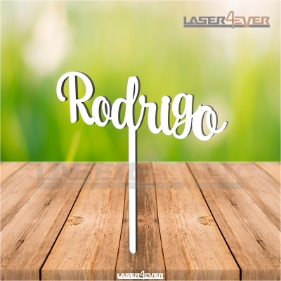 Decoração branca de madeira com o nome 'Rodrigo' sobre mesa de madeira clara