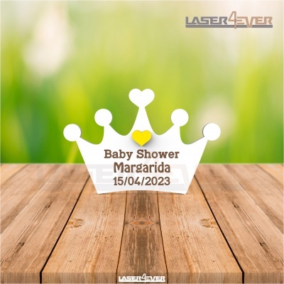 Decoração em forma de coroa branca com coração amarelo e texto para baby shower