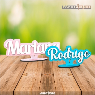 Nomes Mariana e Rodrigo em acrílico sobre mesa de madeira