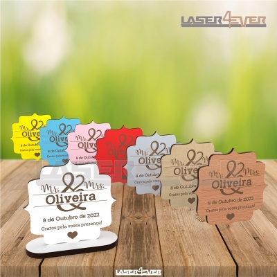 Lembranças de casamento em madeira com texto gravado em várias cores sobre superfície de madeira