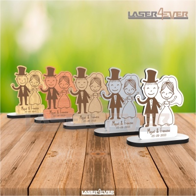 Figuras de noivos personalizadas em várias cores com nomes e data, sobre superfície de madeira.