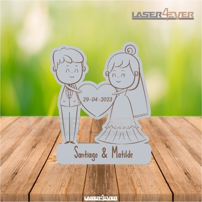 Figura decorativa de casal de noivos com coração com data e nomes sobre madeira.