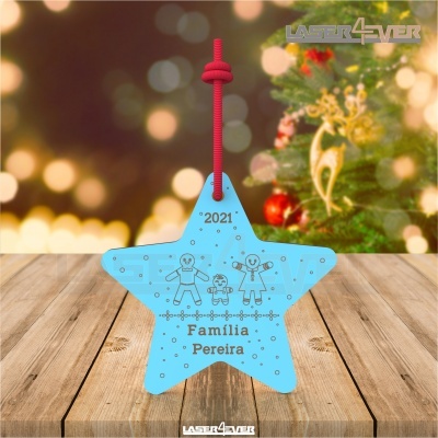 Estrela azul decorativa gravada com texto e bonecos sobre madeira com árvore de Natal ao fundo