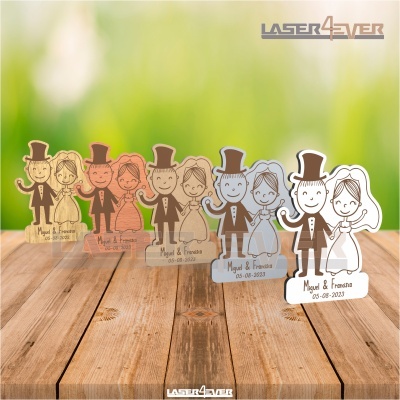 Figuras de noivo e noiva em diferentes materiais e cores com texto Miguel & Francisca 05-08-2023 sobre chão de madeira.