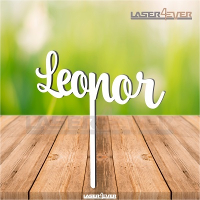 Topper decorativo branco com texto 'Leonor' em letra cursiva sobre mesa de madeira