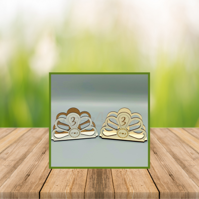 Dois porta-guardanapos em madeira clara e escura com design floral e número 3 no centro.