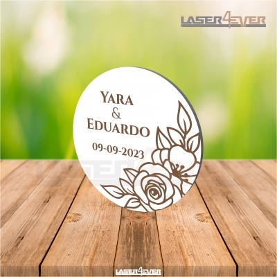Placa redonda branca com nomes e decoração floral e suporte