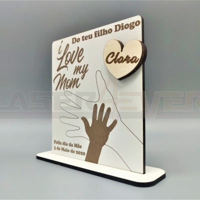 Placa de madeira branca com mãos recortadas e texto gravado para o Dia da Mãe