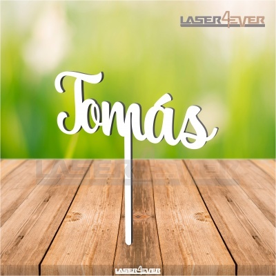 Topo de bolo branco com o nome Tomás em fundo verde desfocado