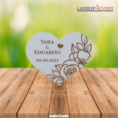 Peça decorativa em formato de coração cinzento com gravura floral castanha e texto gravado