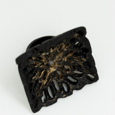 Anel de metal preto e dourado com design recortado