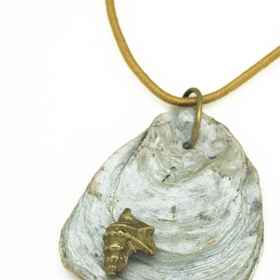 Colar com pendente em formato de concha natural cinza e detalhe decorativo dourado