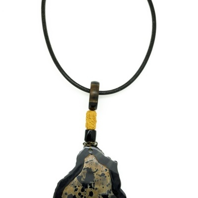 Colar com pendente em pedra irregular preta e bege com padrão salpicado
