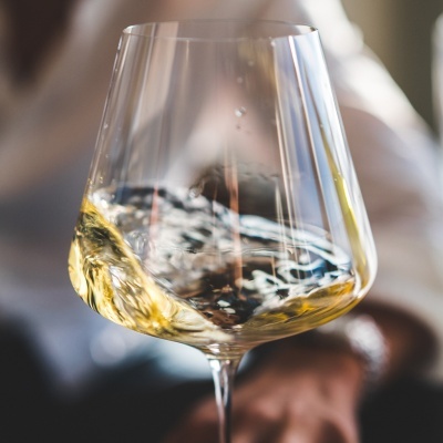 Copo de vidro transparente com vinho branco amarelo claro