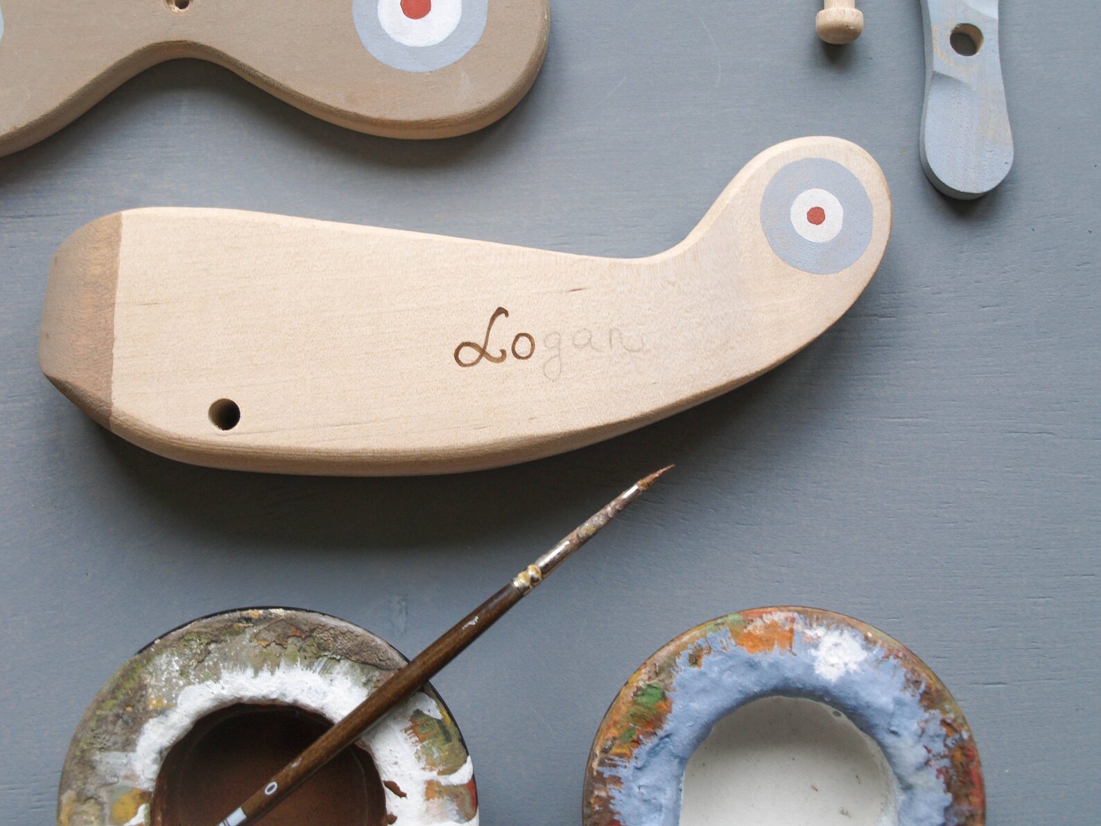 Peças de madeira pintadas, pincel e paletas de tinta colorida