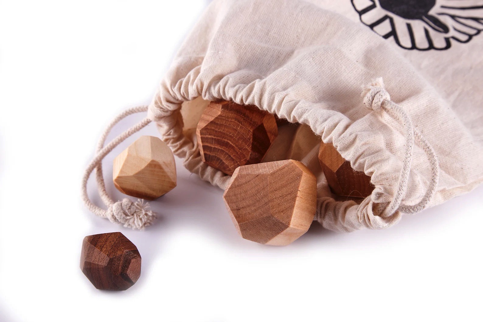 Peças de madeira geométricas junto de bolsa de pano bege