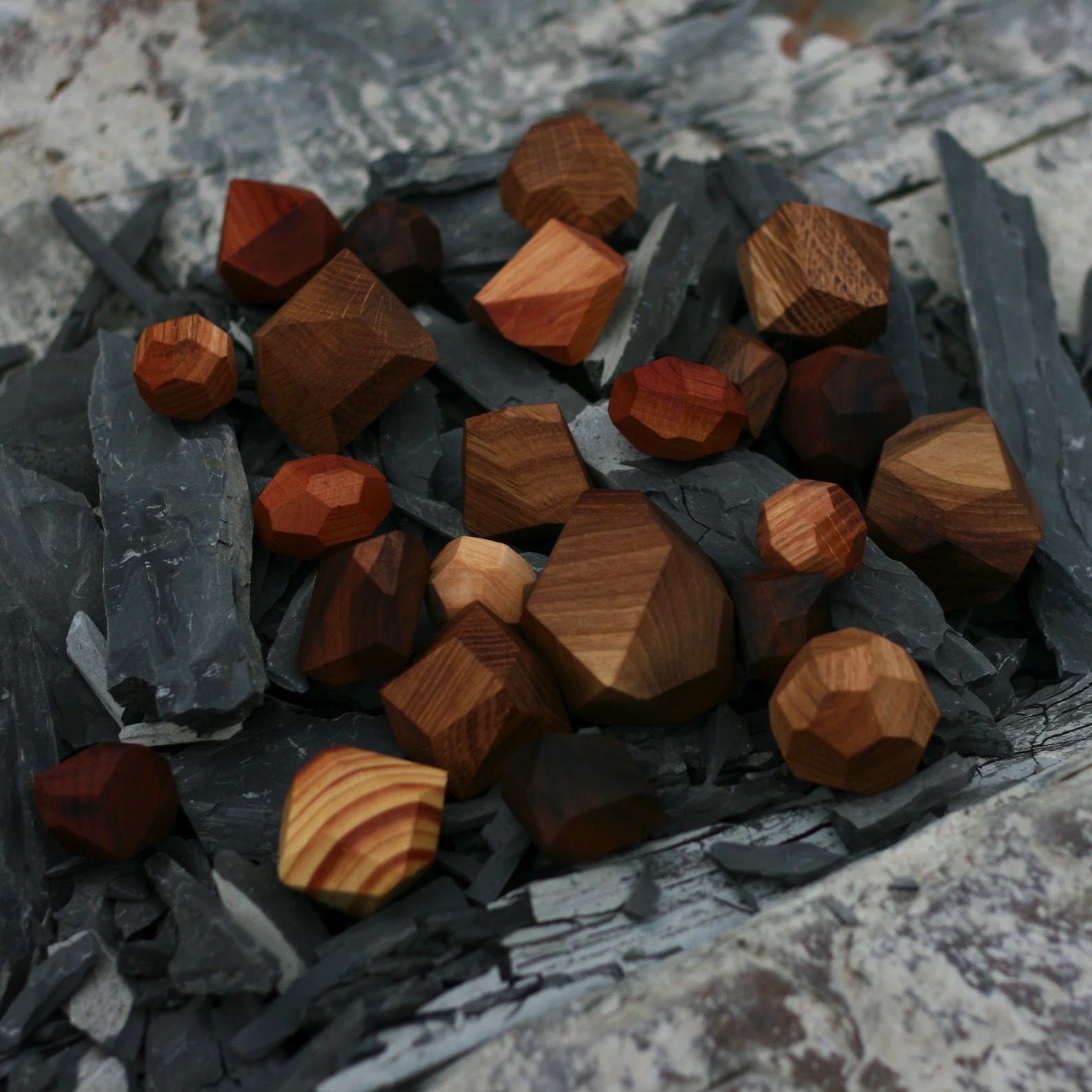 Pedras de madeira poligonais em tons de castanho sobre ardósia cinzenta