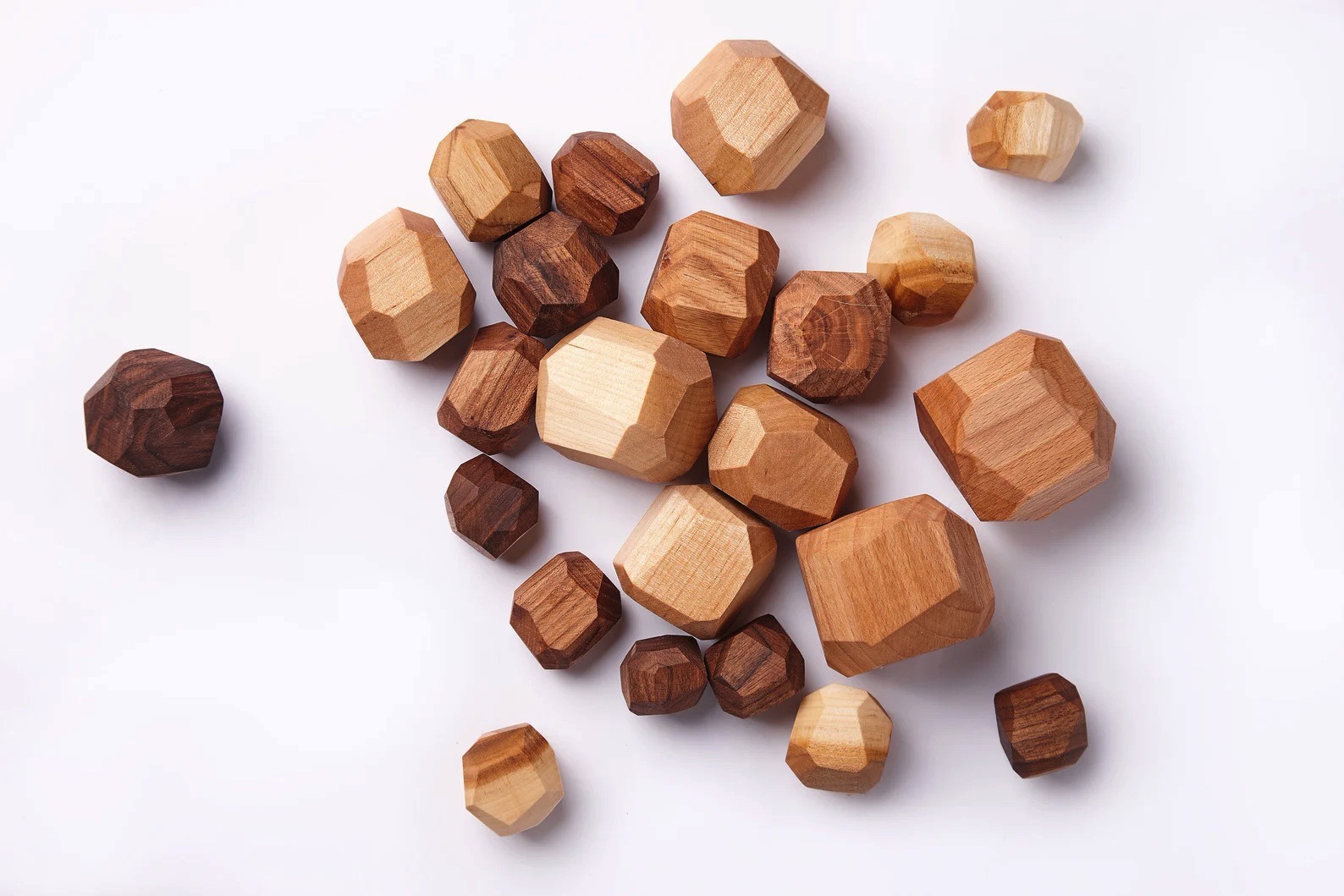 Pedras de madeira poligonais claras e escuras sobre fundo branco