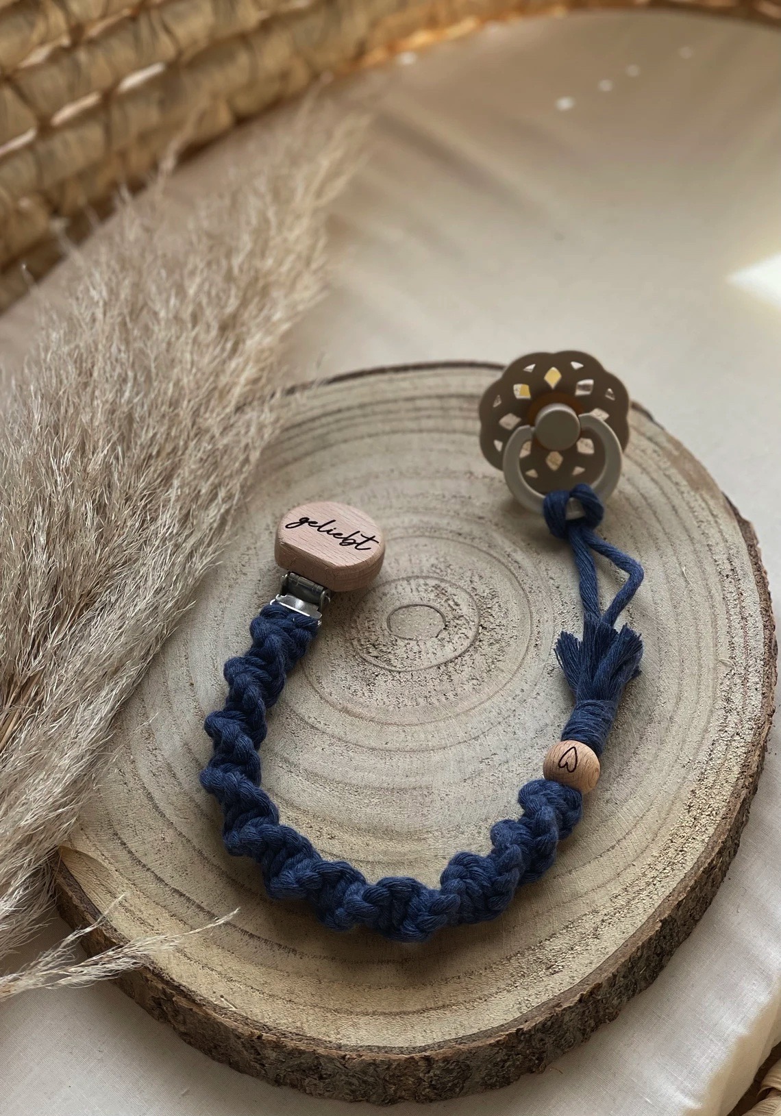 Prendedor de chucha azul com clip de madeira em base rústica