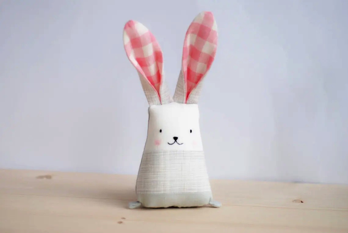 Brinquedo de pelúcia em forma de coelho com orelhas de tecido rosa e branco