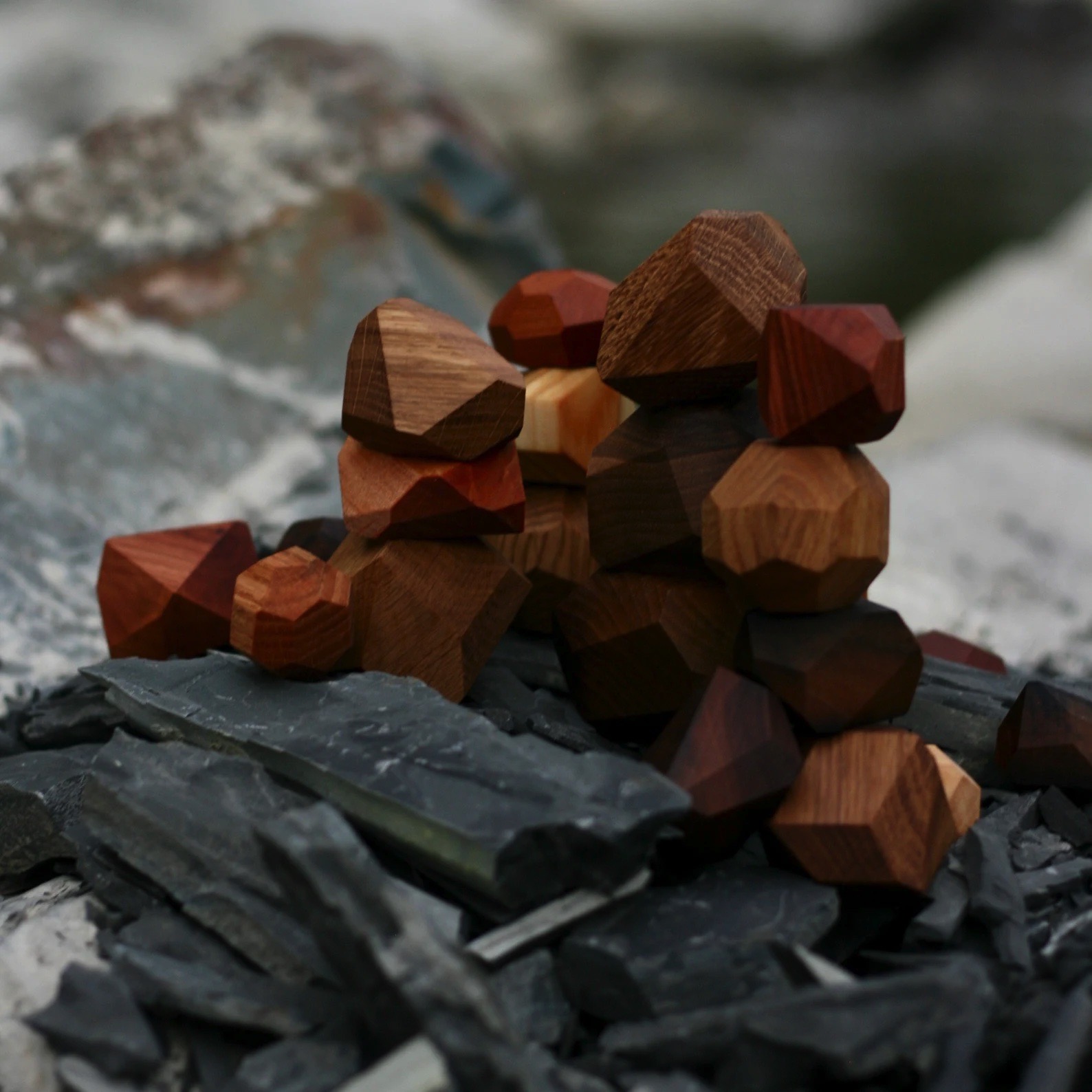 Peças geométricas de madeira colorida empilhadas sobre pedras