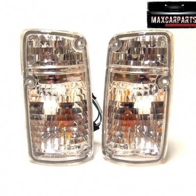 Par de farolins automóvel transparentes com reflexos prateados e etiqueta MAXCARPARTS